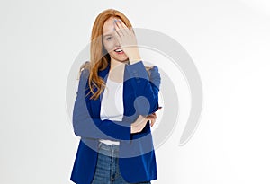 Pretty red hair woman covering her face with hand, Young european girl in dark blue suit hides her face, studio photo isolated on