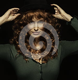 Pretty red-haired girl with curls with frackles, black hat