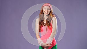 Pretty red-headed girl in pink bodysuit and green leggins in 80s style