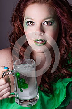 Pretty red headed woman drinking from a Mug with a shamrock on i