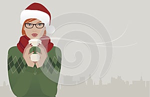 Pretty redhaired girl wearing glasses and a santa hat drinking a hot drink at Christmas.