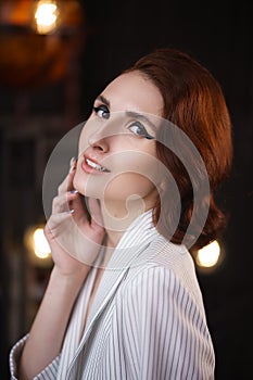 Pretty redhead thin young woman in white unbuttoned pant suit