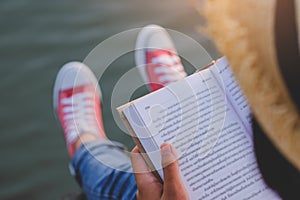 Pretty relaxed young woman reading a book in quiet nature