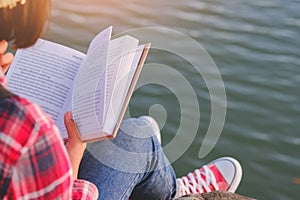 Pretty relaxed young woman reading a book in quiet nature