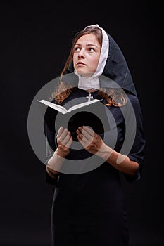 Pretty religious nun against dark background. Religion concept.