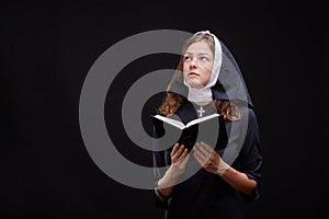 Pretty religious nun against dark background. Religion concept.