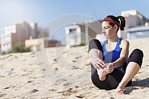 Pretty runner woman runner sitting on sandy beach