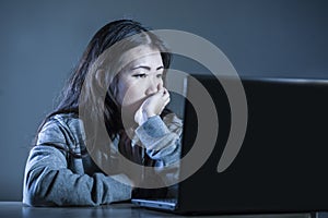 Pretty sad Asian Korean student woman looking depressed and worried studying with laptop computer in stress for exam feeling bored