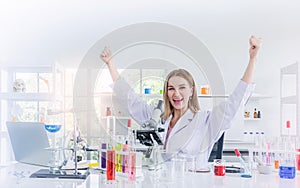 Pretty scientist work reserching and cheerfully in chemical laboratory