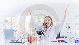 Pretty scientist work reserching and cheerfully in chemical laboratory