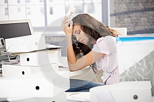 Pretty secretary sitting desperately with phone