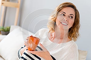 Pretty senior lady drinking tea with joy