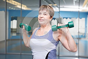 Pretty senior woman exercising in gym