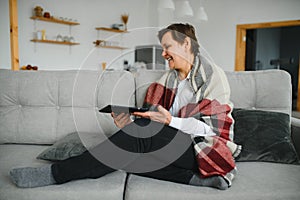 pretty senior woman using tablet computer at home.