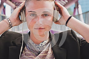 Pretty short hair girl listening to music on a bridge