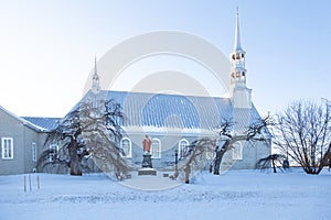 Pretty side view of the 1811 Saint-André catholic church seen in winter on route 132