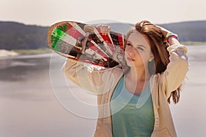 Pretty skater girl holding skateboard