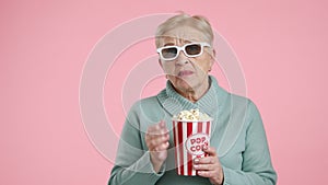 Pretty slim aged woman in 3D glasses eating popcorn holding breath in terror