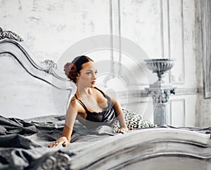 Pretty slim brunette woman resting in luxury room interior, vint