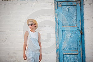 Pretty slim tan blonde stylish woman in straw hat and sunglasses posing