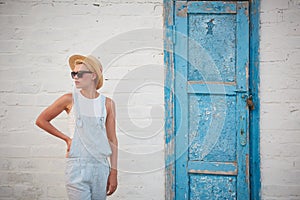 Pretty slim tan blonde stylish woman in straw hat and sunglasses posing