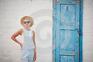 Pretty slim tan blonde stylish woman in straw hat and sunglasses posing