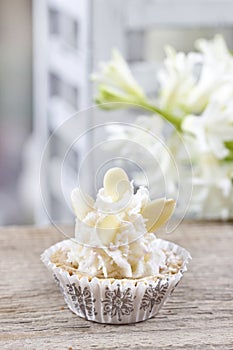 Pretty small cupcakes, lavishly decorated, on wooden table