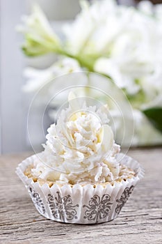 Pretty small cupcakes, lavishly decorated, on wooden table