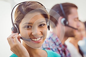 Pretty smiling businesswoman working in a call centre photo