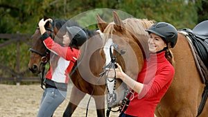 Pretty smiling girl hugging her horse at ranch.