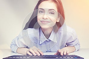 Pretty smiling girl using her keyboard