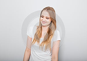 Pretty smiling joyful young woman with fair blond long hair in casual dress looking with happy. Studio shot of good looking