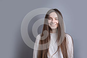 Pretty smiling joyfully female with dark hair, dressed casually, looking with satisfaction at camera, being happy. Studio shot of