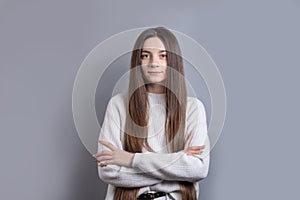 Pretty smiling joyfully female with dark hair, dressed casually, looking with satisfaction at camera, being happy. Studio shot of