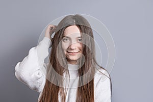 Pretty smiling joyfully female with dark hair, dressed casually, looking with satisfaction at camera, being happy. Studio shot of