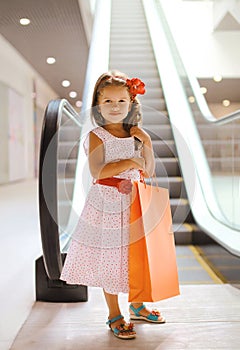 Pretty smiling little girl with shopping bag
