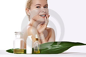 Pretty smiling woman applies organic cosmetic and oils for beauty. Spa and wellness. Clean skin, shiny hair. Healthcare