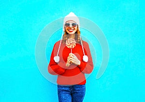 Pretty smiling woman with lollipop in red knitted sweater