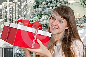 Pretty smiling woman with red gift box
