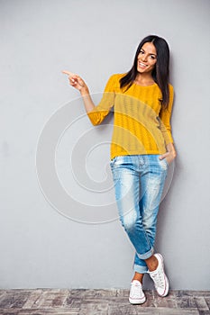 Pretty smiling woman showing finger left