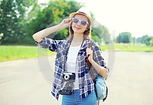Pretty smiling woman wearing straw hat sunglasses and vintage camera
