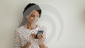 Pretty smiling young woman engaged in using mobile phone device