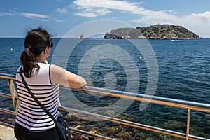 Pretty Spanish tourist woman looking at seascape from small town L Estartit photo
