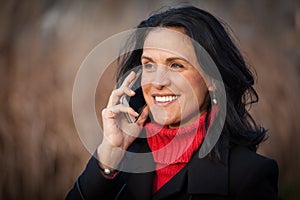 Pretty Spanish Woman Smiling At the camera. Outside having a funny conversation on the phone. Lost in thought.