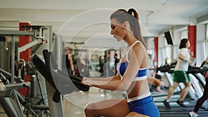 Pretty sportswoman workouts with exercise bike in the gym. 4K
