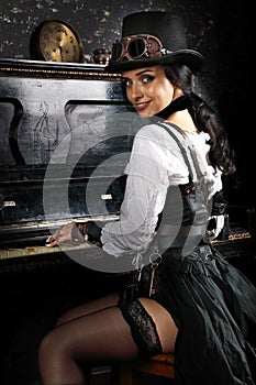 Pretty steampunk girl playing the piano