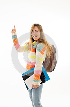 Pretty student teenager woman with schoolbag and books pointing at copy space