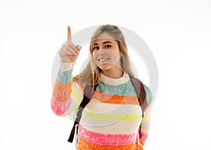 Pretty student teenager woman with schoolbag and books pointing at copy space