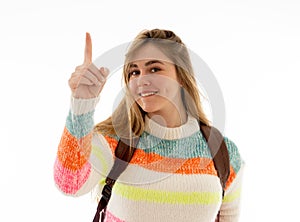 Pretty student teenager woman with schoolbag and books pointing at copy space