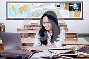 Pretty student using laptop for studying in class